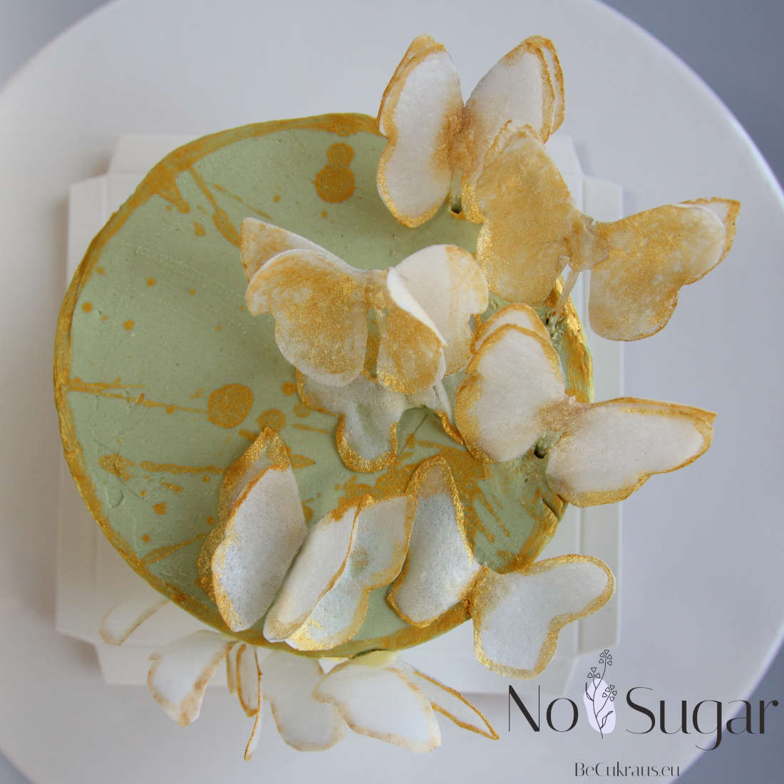 Gold paint on a bento cake and the wings of butterflies sitting on it