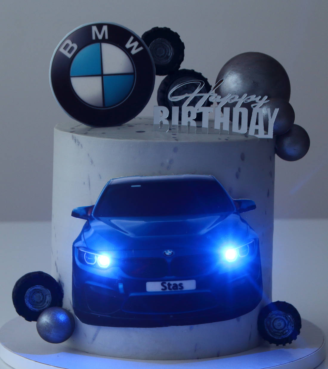 Šviečiančios LED lemputės ant torto su BMW automobiliu