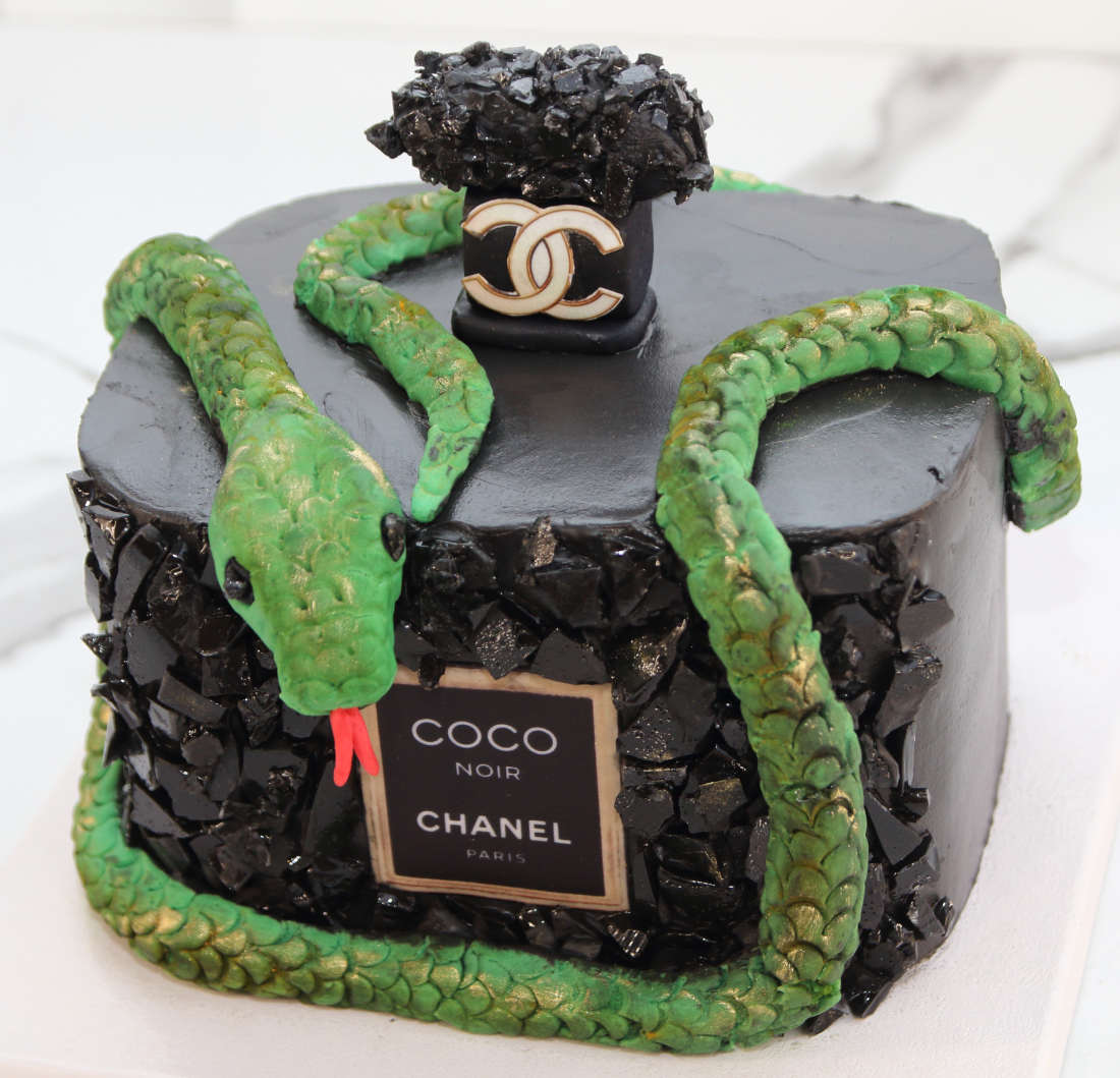 Gyvatė ant juodo kvepalų buteliuko formos torto