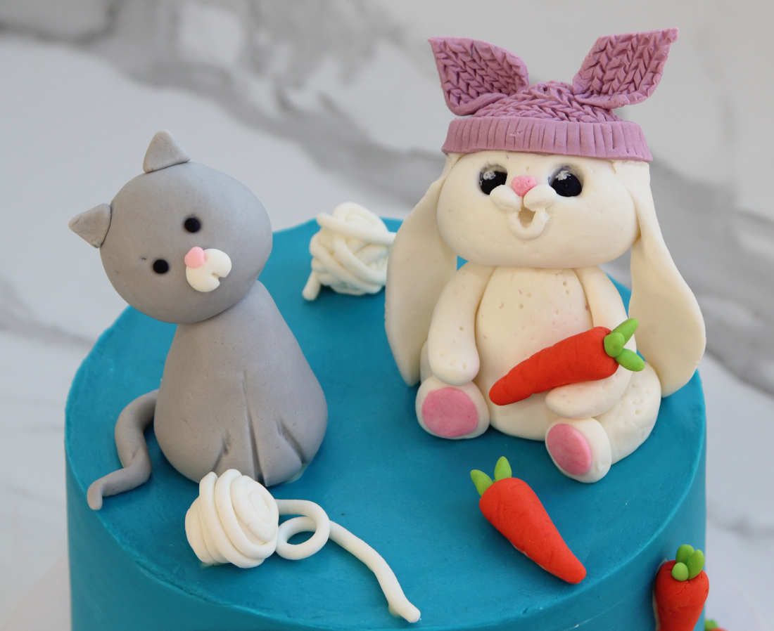 Cat with balls of yarn and the hare with a carrot on the cake for a man's birthday