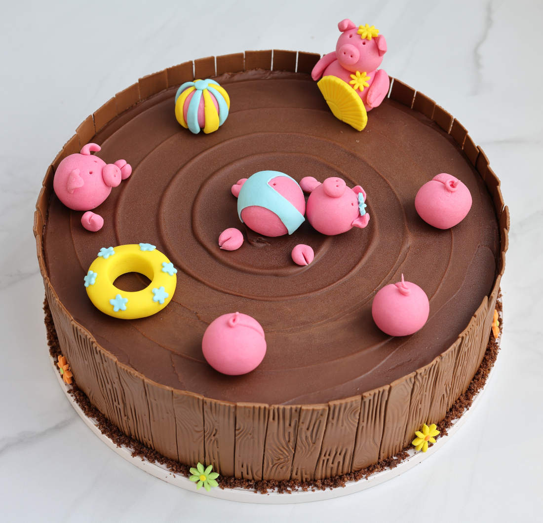A funny cake with a chocolate puddle, a fence, and pigs