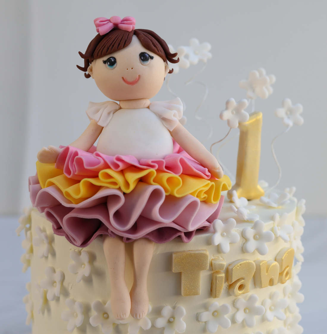A girl in a skirt on a cake with white flowers