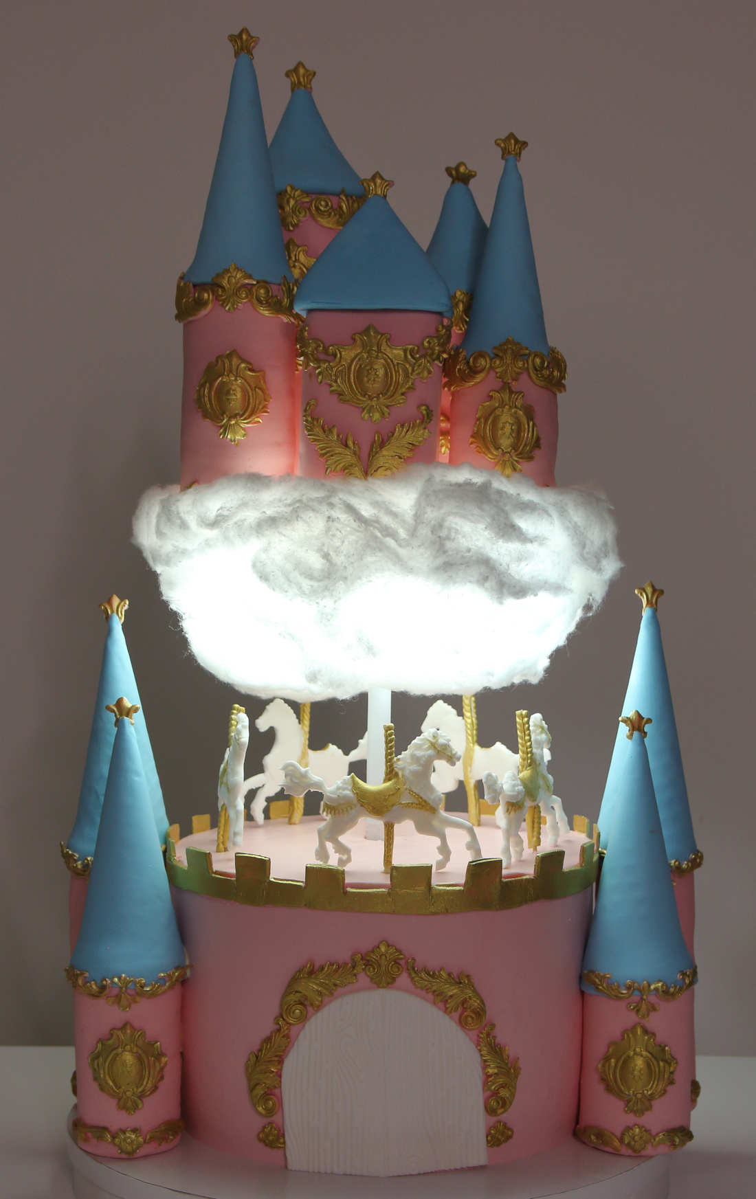 Karuselė ant torto su žiburiais ir pilimi