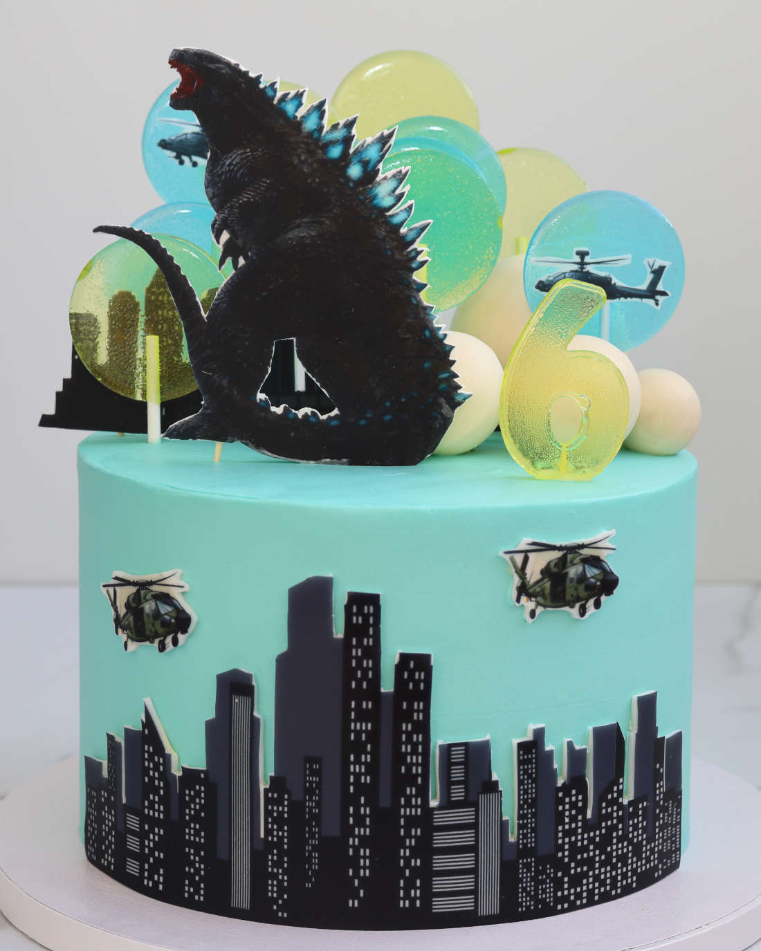 Godzila ant torto, apsupta ledinukų ir sraigtasparnių