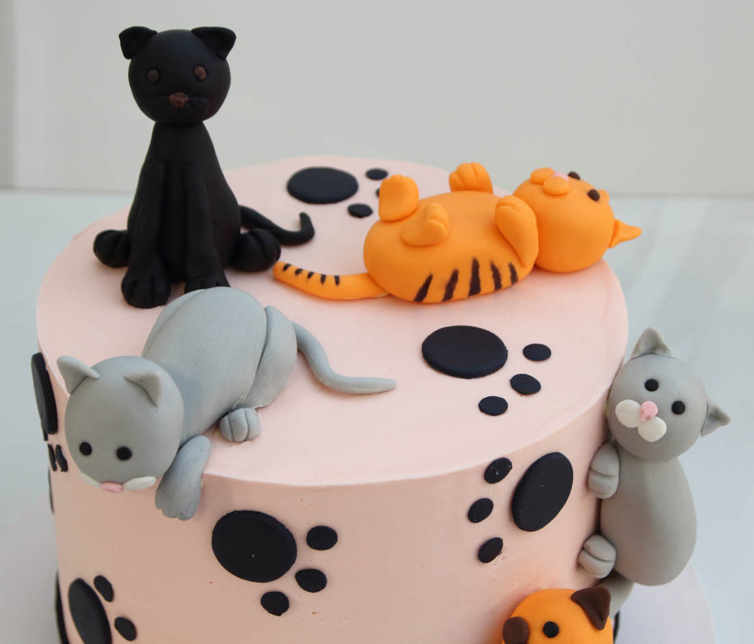 Colorful cats on a birthday cake
