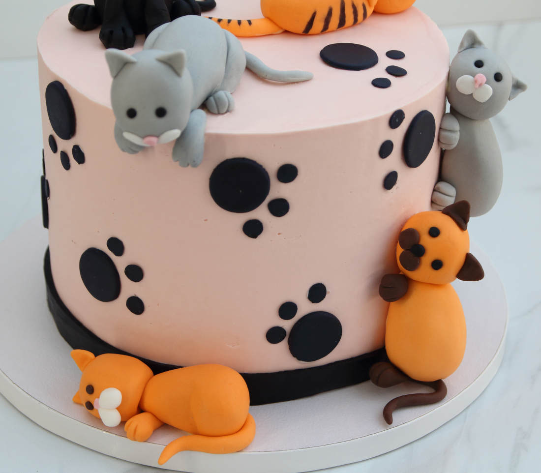 Cake with playing, sitting and lying cats