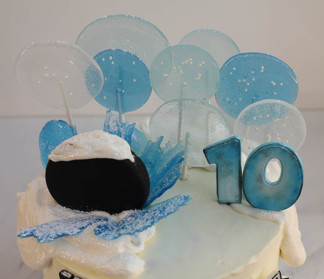 Lollipops and a hockey puck on the cake
