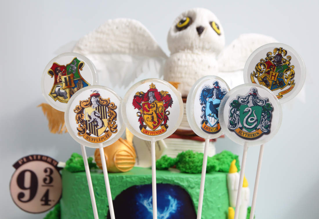 Lollipops with the coats of arms of Hogwarts Houses and Harry Potter cake
