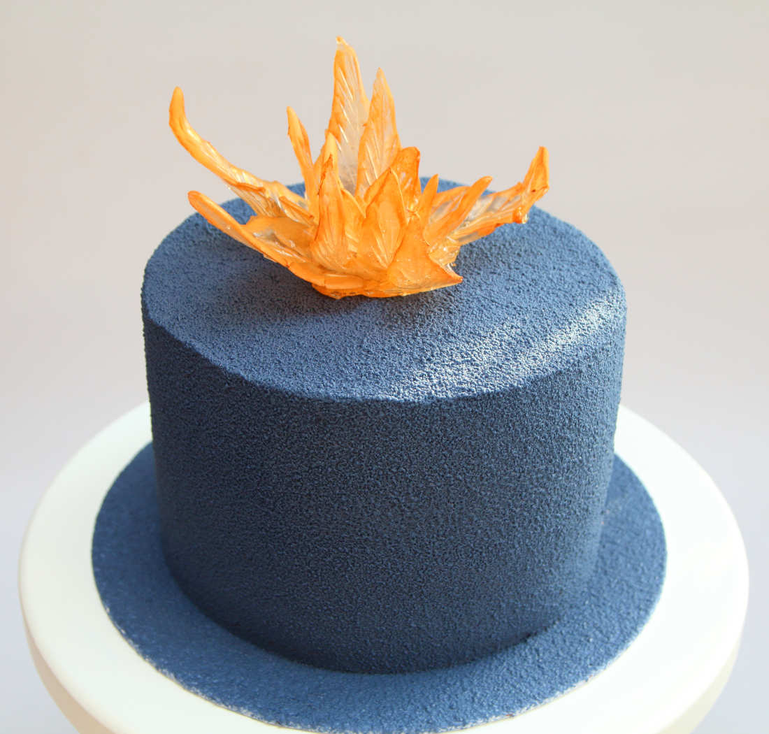 Cake with pistachios and raspberries covered with chocolate velor