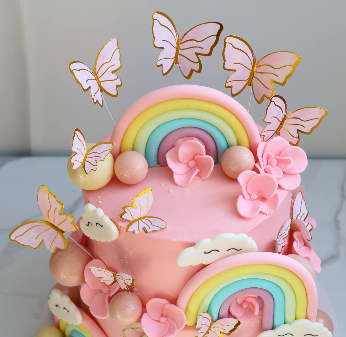 Cake with rainbow, butterflies, and flowers