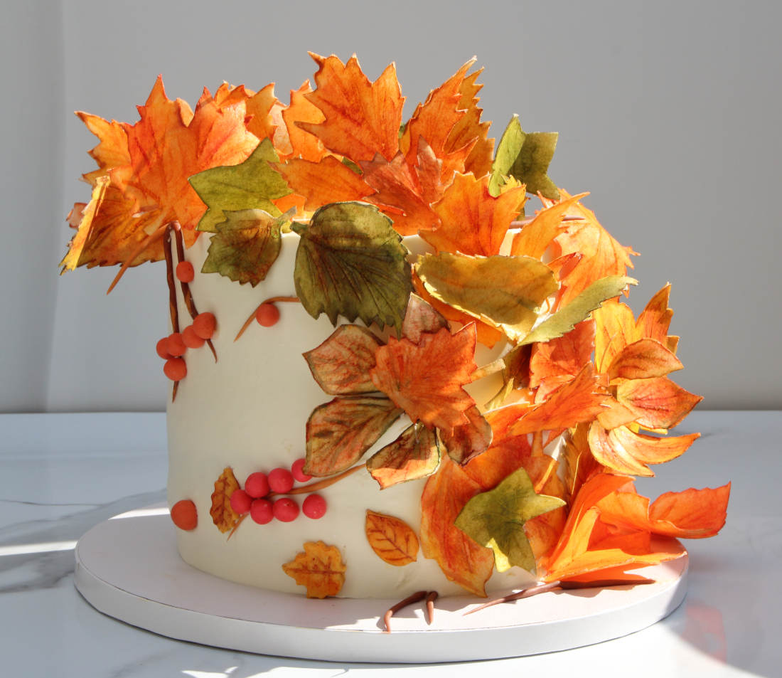 Oranžiniai, geltoni ir žali lapai ant rudens torto