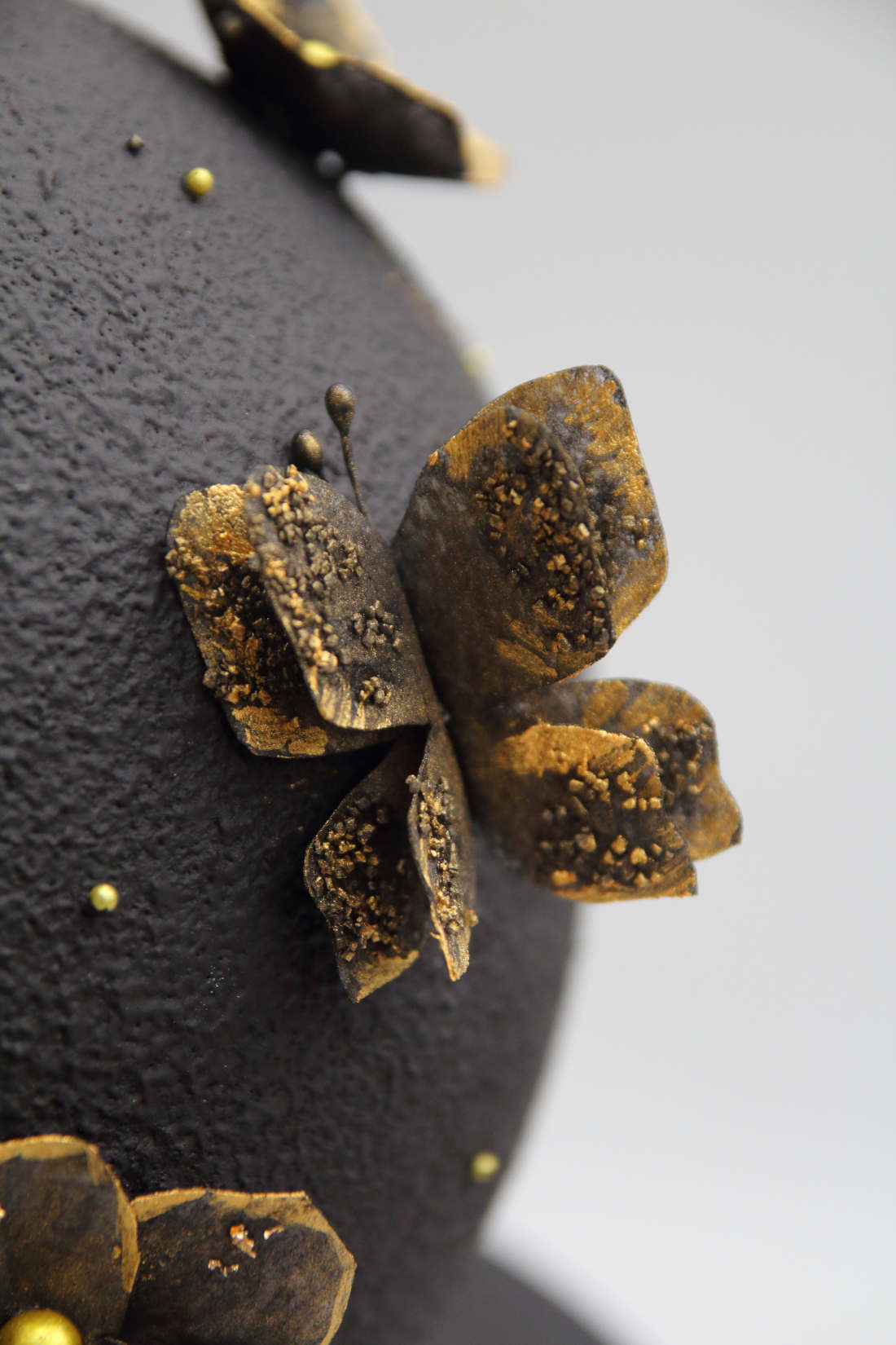 Butterfly with golden wings on the black ball cake