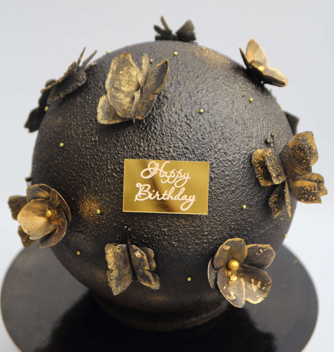 Birthday ball cake with golden flowers and butterflies