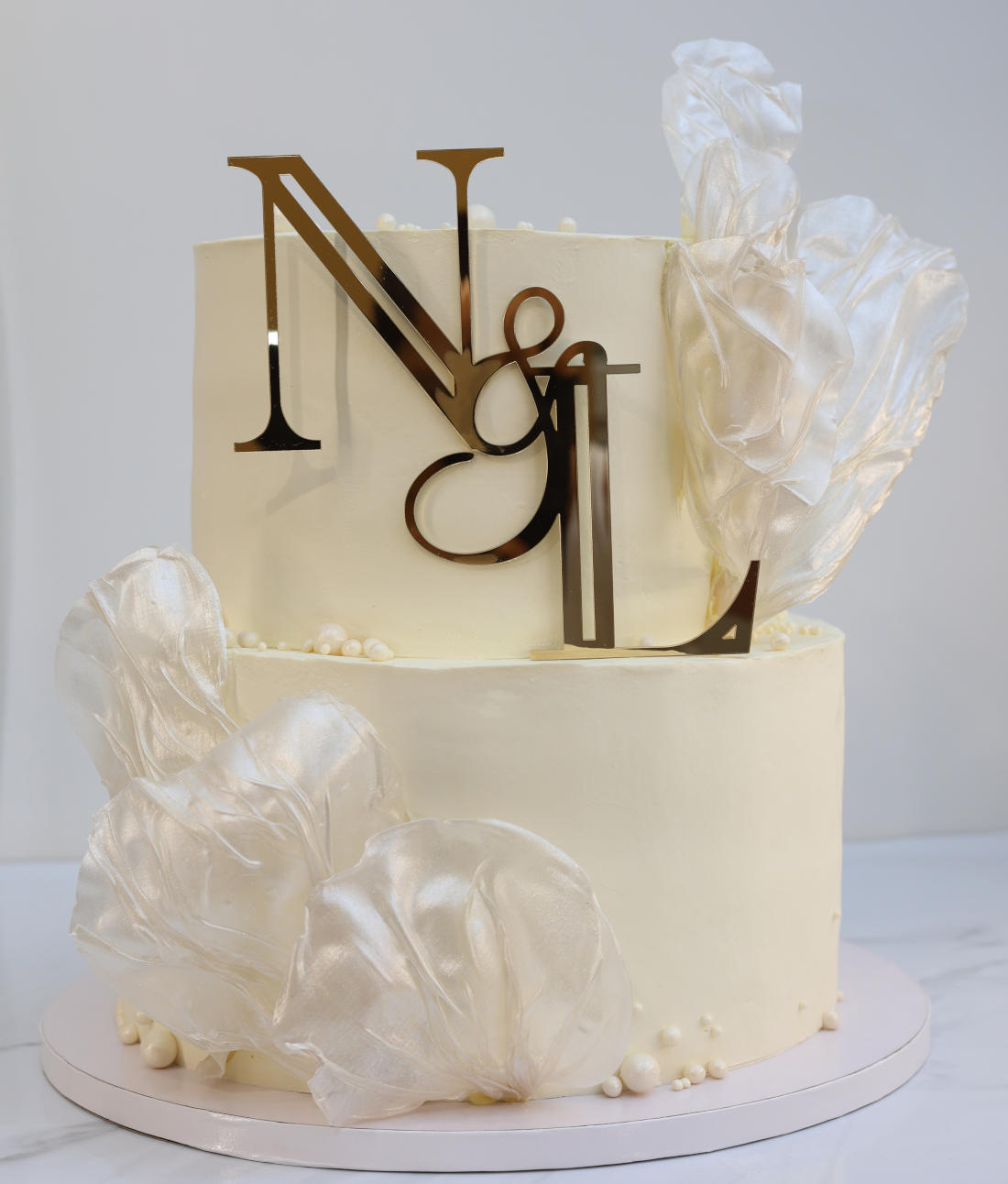 Wedding cake with the newlyweds' initials and rice paper sails