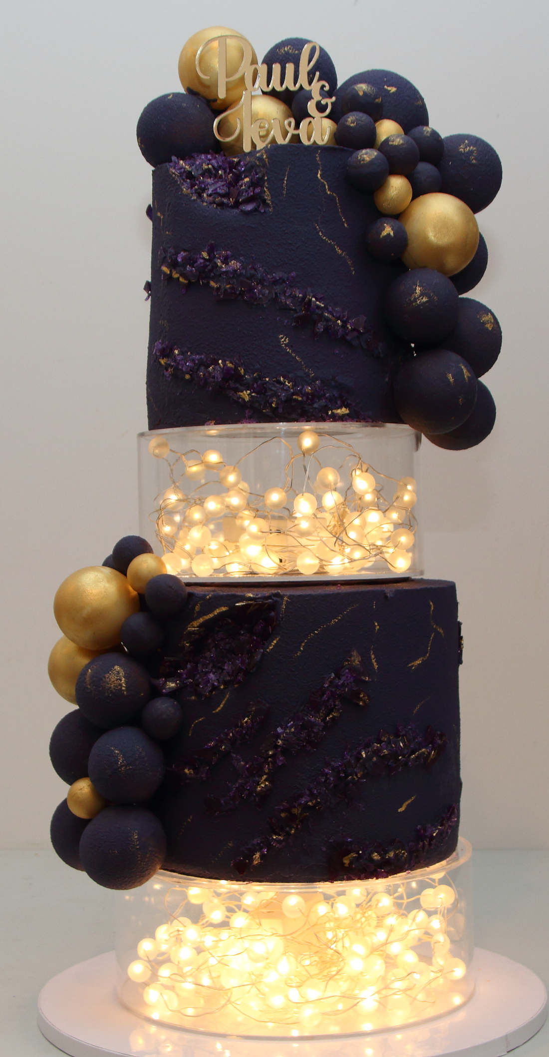 Four-tier wedding cake with chocolate velour and LED garlands